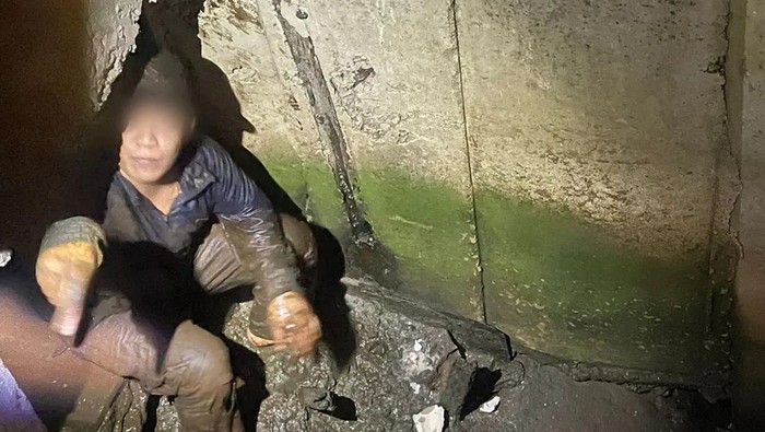 Terduga begal bersembunyi ketakutan di gorong-gorong di daerah Cengkareng, saat banyak warga mengejar. Ternyata dia mau transaksi narkoba. (dok Polres Jakbar)