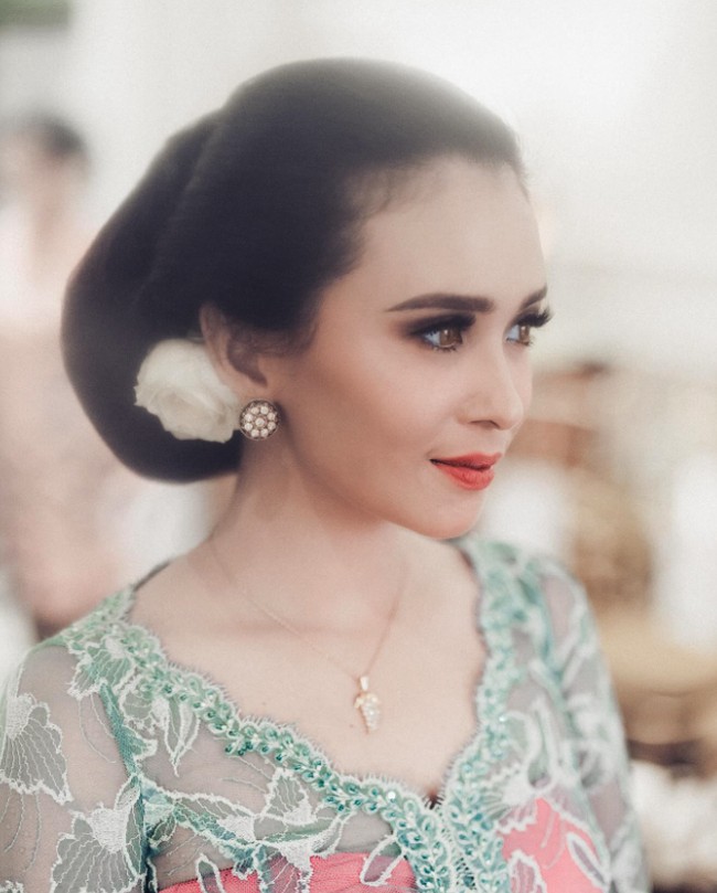 Dalam prosesi langkahan jelang pernikahan Wira, Ayushita mengenakan kebaya kartini bernuansa hijau dan kemben warna pink. Ia tampak ayu dengan sanggul khas Jawa yang diselipkan mawar putih. Foto: Instagram @ayushita