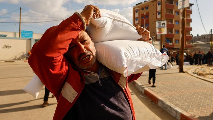 ISRAEL-PALESTINIANS/ Palestinians gather to receive flour bags distributed by UNRWA in Rafah, in the southern Gaza Strip November 21, 2023. REUTERS/Ibraheem Abu Mustafa