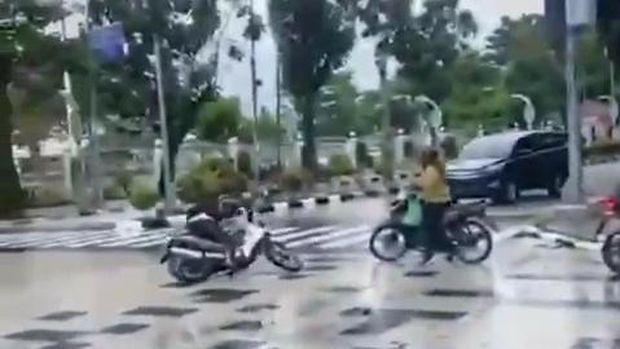 Jalan licin di Medan yang membuat pengendara tergelincir. (Istimewa)