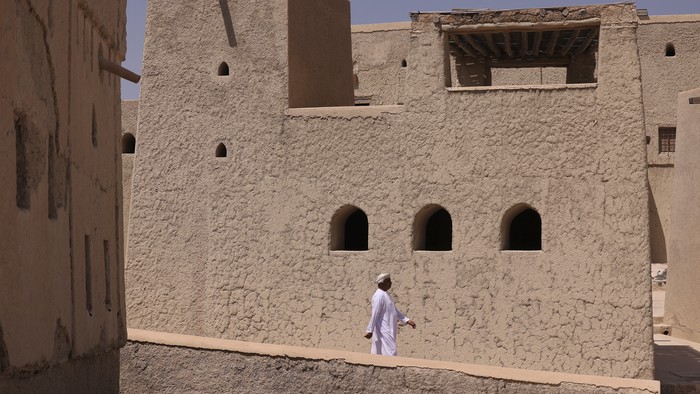 A man walks at Bahla Fort, one of four historical forts located at the foot of the Green Mountain highlands of Oman, and the only fort in the country designated a UNESCO Heritage Site, in Bahla, 200km north of Muscat, on October 5, 2023. (Photo by Karim SAHIB / AFP)