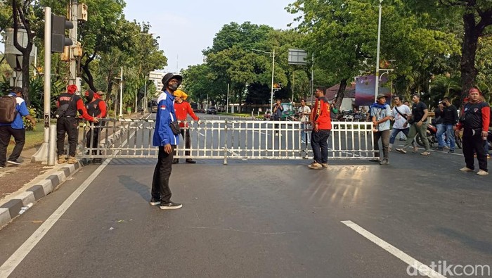 Massa buruh menggotong pagar Balai Kota DKI Jakarta ke tengah jalan. (Tiara/detikcom)