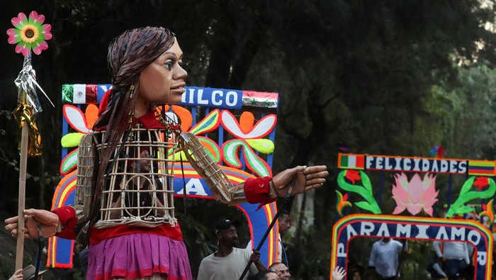 Little Amal, a 12-foot-tall puppet depicting a 10-year-old Syrian refugee, rides a boat on a water canal in Xochimilco on the outskirts of Mexico City, Mexico November 19, 2023.  REUTERS/Raquel Cunha
