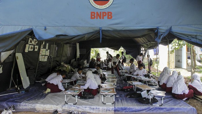 Dua orang siswa duduk di tenda sekolah darurat SDN Cugenang, Cijedil, Cugenang, Kabupaten Cianjur, Jawa Barat, Selasa (21/11/2023). Sebanyak 120 siswa masih melaksanakan kegiatan belajar mengajar di tenda sekolah darurat setelah satu tahun gempa mengguncang Kabupaten Cianjur. ANTARA FOTO/Henry Purba/rwa. *** Local Caption *** ,