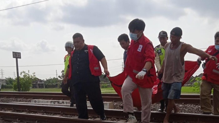 Petugas kepolisian dibantu PMI mengevakuasi jenazah Sri Harjono (69), yang tewas menabrak KA di Klaten Rabu (22/11/2023).