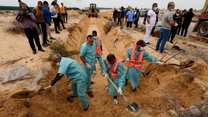 The bodies of Palestinians killed in Israeli strikes and fire are buried in a mass grave, after they were transported from Al Shifa hospital in Gaza City for burial, in Khan Younis in the southern Gaza Strip November 22, 2023. REUTERS/Mohammed Salem