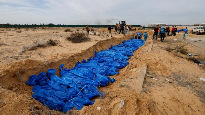 The bodies of Palestinians killed in Israeli strikes and fire are buried in a mass grave, after they were transported from Al Shifa hospital in Gaza City for burial, in Khan Younis in the southern Gaza Strip November 22, 2023. REUTERS/Mohammed Salem