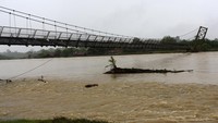 Tampak lantai jembatan miring usai diterjang banjir. 