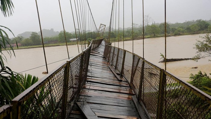 Jembatan gantung penghubung Kecamatan Pante Ceureumen dan Kecamatan Panton Reu rusak akibat diterjang banjir di Desa Menuang Kinco, Pante Ceureumen, Aceh Barat, Aceh, Selasa (21/11/2023). Tingginya intensitas hujan dan meningkatnya debit air Sungai krueng Meureubo sejak Senin (20/11/2023) mengakibatkan lantai dan tali penyangga jembatan gantung putus. ANTARA FOTO/Syifa Yulinnas/rwa.