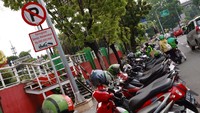 Para driver Ojol ini parkir di bahu jalan sambil menunggu orderan datang. 