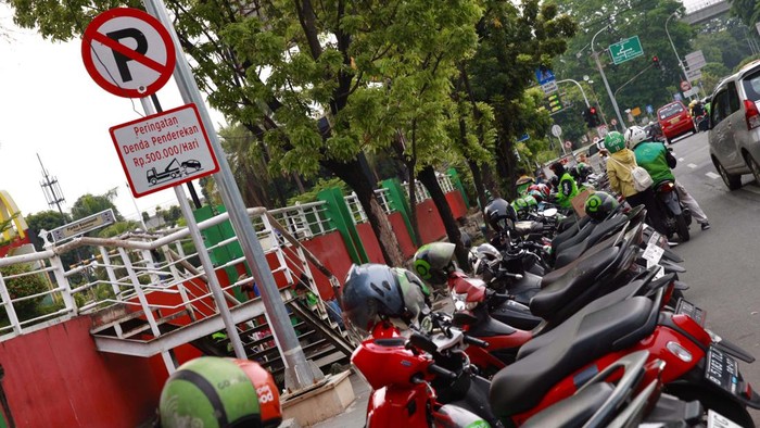 Potret Ojol Parkir Sembarangan di Kawasan Pinang Ranti Driver ojek online parkir sembarangan di depan Tamini Square, Jakarta. Aksi tak tertib itu akan mengganggu pengendara dan pejalan kaki yang melintas.