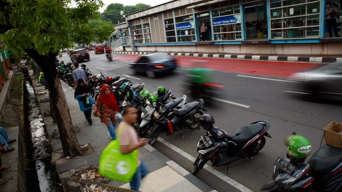 Driver ojek online parkir sembarangan di depan Tamini Square, Jakarta. Aksi tak tertib itu akan mengganggu pengendara dan pejalan kaki yang melintas.