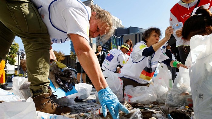 Members of team UK pose with their victory trophy at an award ceremony during a trash picking competition known as 