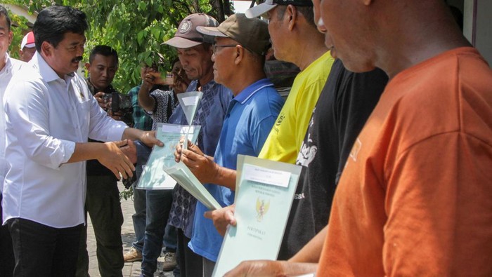 Menteri Agraria dan Tata Ruang/Kepala Badan Pertanahan Nasional (ATR/BPN) Hadi Tjahjanto (kiri) menyerahkan sertifikat tanah hasil program Pendaftaran Tanah Sistematis Lengkap (PTSL) dan Penerimaan Negara Bukan Pajak (PNBP) di Perumahan Reno Joyo, Desa Kedungsolo, Kecamatan Porong, Sidoarjo, Jawa Timur, Kamis (23/11/2023). Kementerian Agraria Tata Ruang/Badan Pertanahan Nasional (BPN) melalui Kantor Pertanahan Sidoarjo menyerahkan sekitar 640 sertifikat tanah kepada korban bencana alam Lumpur Lapindo yang direlokasi ke Perumahan Reno Joyo setelah menunggu hampir 15 tahun lamanya. ANTARA FOTO/Umarul Faruq/Spt.