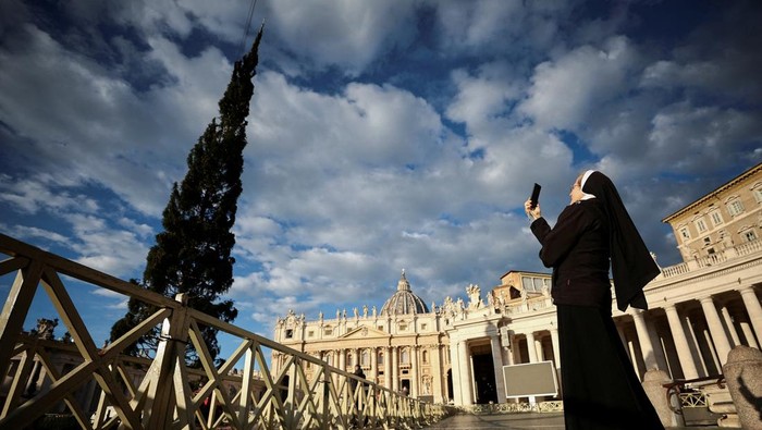 A nun takes a video as a Christmas tree arrives in St. Peter's Square ahead of the festive season at the Vatican, November 23, 2023. REUTERS/Guglielmo Mangiapane     TPX IMAGES OF THE DAY