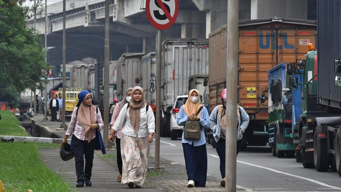 Jalan Tol Jakarta-Cikampek Macet Parah Gegara Demo Buruh Sejumlah pekerja berjalan kaki karena akses kendaraan menuju kawasan Industri MM 2100 ditutup buruh yang melakukan aksi di Kabupaten Bekasi, Jawa Barat (23/11/2023). Akses jalan untuk truk angkut barang serta kendaraan pribadi menuju kawsan Industri MM 2100 dan keluar kawasan tersebut ditutup buruh yang melakukan aksi menuntut kenaikan UMP Jawa Barat 2024. ANTARA FOTO/ Fakhri Hermansyah/tom.