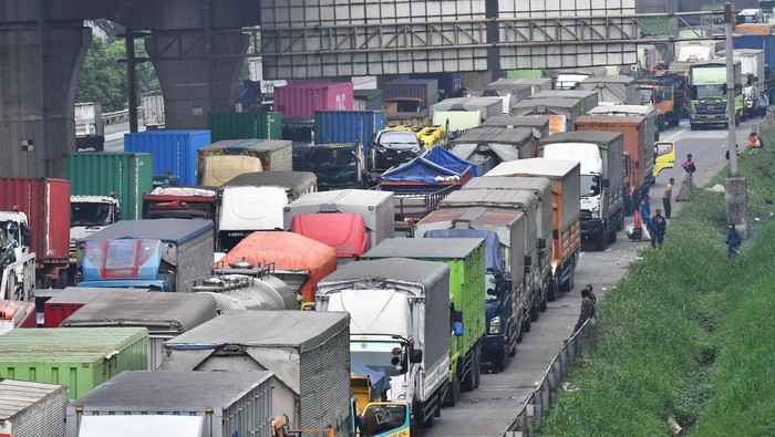 Sejumlah pekerja berjalan kaki karena akses kendaraan menuju kawasan Industri MM 2100 ditutup buruh yang melakukan aksi di Kabupaten Bekasi, Jawa Barat (23/11/2023). Akses jalan untuk truk angkut barang serta kendaraan pribadi menuju kawsan Industri MM 2100 dan keluar kawasan tersebut ditutup buruh yang melakukan aksi menuntut kenaikan UMP Jawa Barat 2024. ANTARA FOTO/ Fakhri Hermansyah/tom.