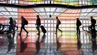 Orang-orang berjalan ke gerbang penerbangan di Bandara Internasional O’Hare di Chicago, Illinois, Amerika Serikat, Rabu (22/11/2023).  