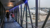 Penumpang melintasi garbarata saat menaiki pesawat di Bandara Soekarno Hatta , Tangerang, Banten, Kamis (23/11/2023).