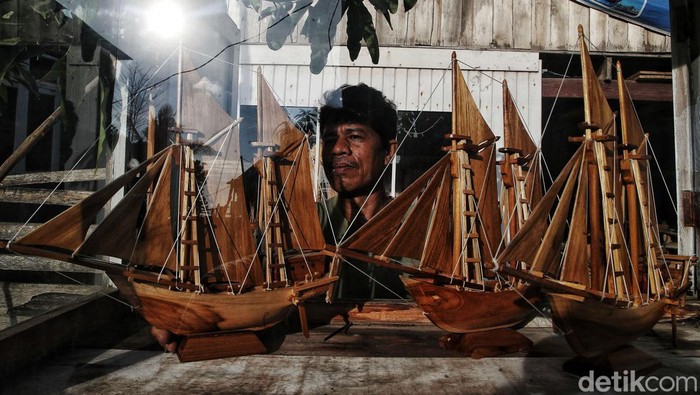Miniatur Kapal Pinisi Tanah Beru yang Mendunia Seorang perajin membuat miniatur kapal pinisi di Tanah Beru, Bulukumba, Sulawesi Selatan, Kamis (2/11/2023).