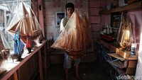Rajanuddin menunjukkan miniatur kapal pinisi yang telah jadi dan siap untuk dipasarkan.  