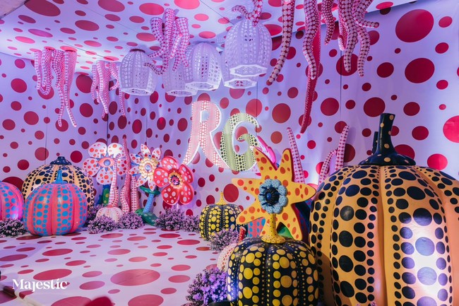 Dekorasi unik lainnya dalam pernikahan pasangan crazy rich Surabaya ini adalah hadirnya instalasi seni ala seniman Jepang Yayoi Kusama. Tamu disambut dengan photo spot dengan dekorasi kontemporer yang mengambil inspirasi dari Yayoi Kusama. Sudut unik ini dipenuhi dengan dekorasi labu raksasa dengan motif polkadot yang iconic ala Yayoi.  Foto: Dok. Majestic Wedding