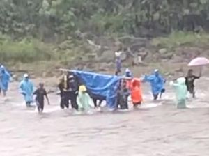 Ngeri! Warga Tandu Jenazah Seberangi Sungai Berarus Deras gegara Jalan Rusak