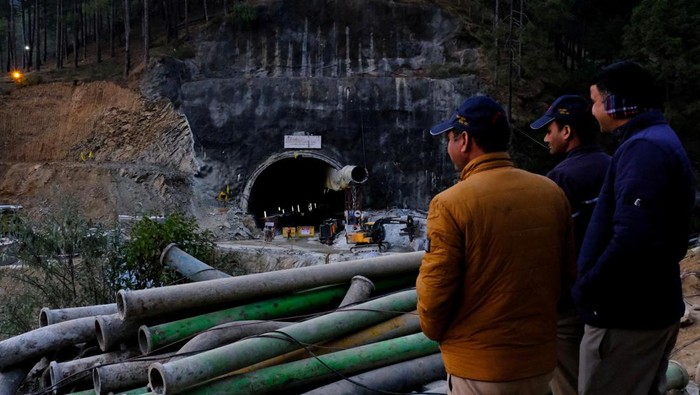 Potret 41 Pekerja India Sudah 10 Hari Terjebak di Terowongan Runtuh Men overlook the entrance of a tunnel where workers have been trapped for ten days after the tunnel collapsed in Uttarkashi, in the northern state of Uttarakhand, India, November 22, 2023. REUTERS/Shankar Prasad Nautiyal NO RESALES. NO ARCHIVES. TPX IMAGES OF THE DAY