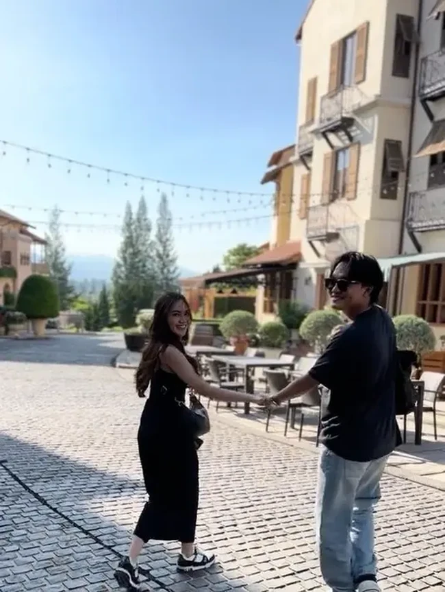 Kompak mengenakan busana hitam, ekspresi bahagia tampak jelas di wajah pasangan tersebut. Tetap romantis dan mesra, keduanya selalu bergandengan tangan. Foto: Instagram/@rizkyfbian