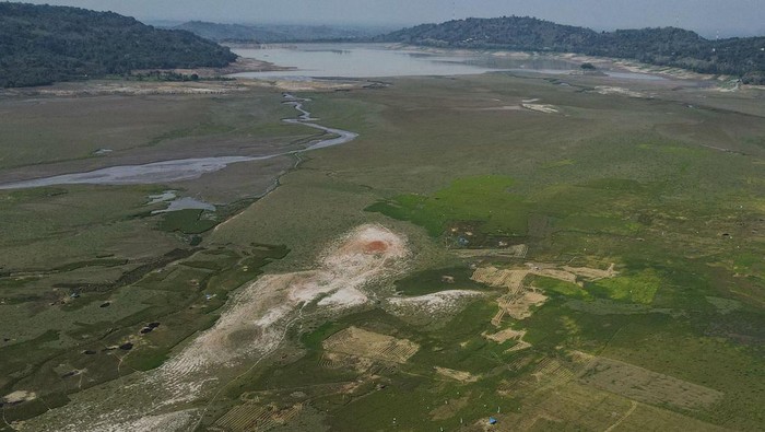 Warga Manfaatkan Waduk Bili-bili yang Mengering Jadi Area Persawahan Foto udara area genangan Waduk Bili-Bili yang mengering akibat kemarau di Kabupaten Gowa, Sulawesi Selatan, Kamis (23/11/2023). Warga setempat memanfaatkan area genangan waduk yang mengering untuk menanam padi, jangung, dan sayuran serta sebagian lainnya menjadi lahan menggembala ternak. ANTARA FOTO/Arnas Padda/Spt.