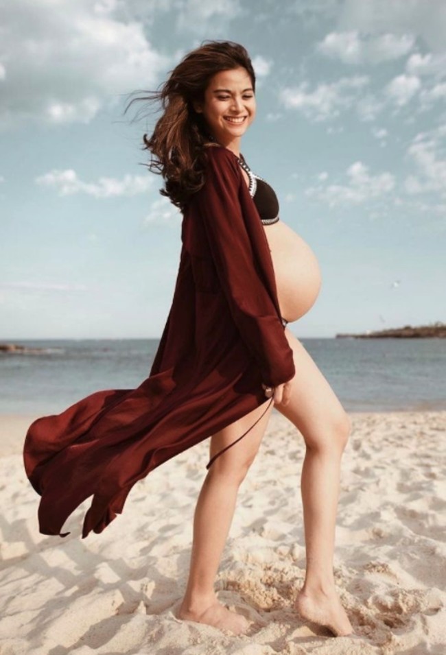 Acha Septriasa tampil memesona dengan bikini warna hitam dan outerwear marun saat pamer baby bump di pantai. Foto: Instagram @septriasaacha