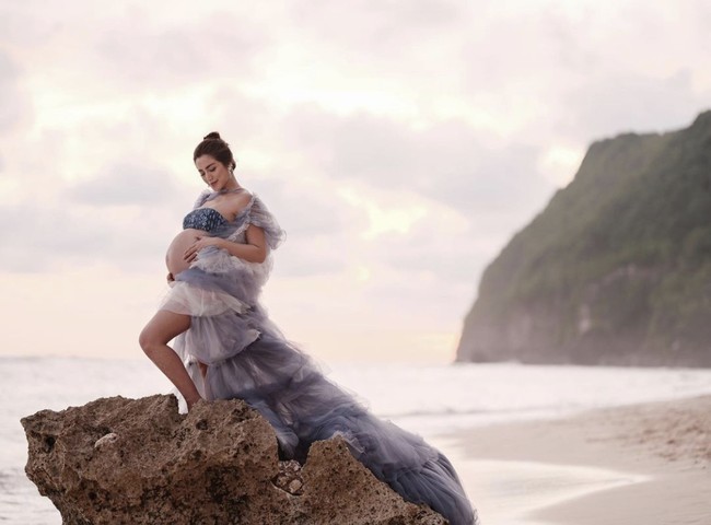 Salah satu selebriti yang melakukan pemotretan kehamilan di pantai adalah Jessica Iskandar. Ia mengenakan bikini motif dihiasi dengan rok mullet layering yang menjuntai demi memberikan sentuhan mewah saat pemotretan di pantai Karma Kandara, Bali. Foto: Instagram @inijedar