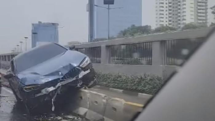 BMW 2 pintu kecelakaan hingga nangkring di separator depan DPR, Jalan Gatot Subroto, Jumat (14/11/2023) siang.