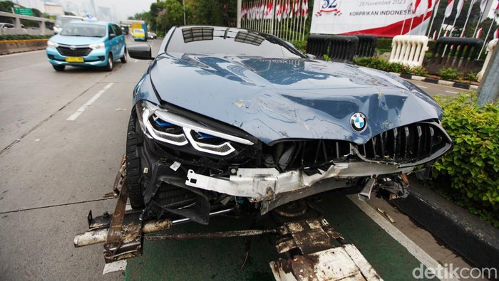 Mobil sport BMW kecelakaan menabrak separator busway di depan DPR, Jakarta, Jumat (24/11/2023). Imbas kecelakaan, lalin arah Slipi macet.