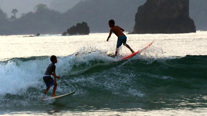 Peselancar berlatih menaklukan ombak di pantai Pulau Merah, Banyuwangi, Jawa Timur, Kamis (23/11/2023). Pemerintah daerah setempat menata Pulau Merah dengan konsep sport tourism untuk menarik kunjungan wisatawan minat khusus karena memiliki keunggulan karakteristik ombak tinggi namun tidak terlalu dalam sehingga menjadi salah satu tempat yang cocok dan aman bagi peselancar pemula maupun profesional. ANTARA FOTO/Budi Candra Setya/nym.