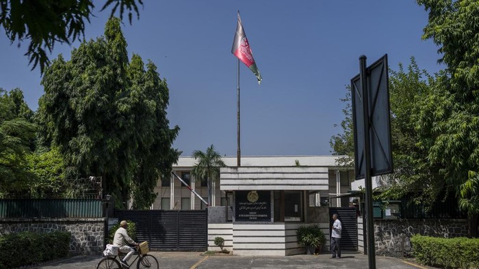 People stand outside the Afghan Embassy in New Delhi, India, Friday, Sept. 29, 2023. India's External Affairs Ministry is examining a letter from the Afghan Embassy that says it plans to cease all operations in the Indian capital by Saturday, an official said Friday. India has not recognized the Taliban government which seized power in Afghanistan in August 2021. It evacuated its own staff from Kabul ahead of the U.S. withdrawal from Afghanistan two years ago and no longer has a diplomatic presence there. (AP Photo)