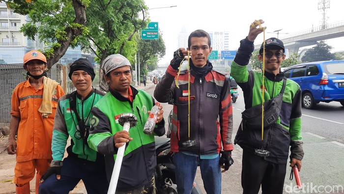 Usmanto (memegang tongkat magnet) dan kawan-kawan sesama penyapu ranjau paku di Jl Gatsu-Jl MT Haryono, Jakarta, 24 November 2023. (Annisa Aulia R/detikcom)