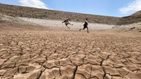 Anak-anak laki-laki bermain di bendungan yang mengering di Khawlan, Yaman.  