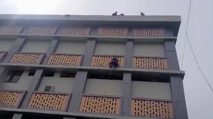 Damkar Padang mengevakuasi kucing yang terjebak di dinding kampus UNP. (Dok Istimewa)