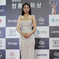 Ahn Eun Jin tampil simple sekaligus glamor mengenakan tube dress bahan fishnet dipadu kain satin. Aksen draperi memberi sentuhan feminin. Foto: AP/Lee Jin-man