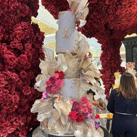 Terdiri dari beberapa tingkat, kue pernikahan yang didominasi warna soft gold dengan sentuhan ornamen bunga berwarna merah muda bisa menjadi pertimbangan. Perpaduan warna tersebut membuat kue terlihat elegan namun tetap tidak berlebihan. Foto: Wolipop/Vina Oktiani