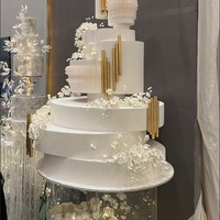 Simpel namun tetap elegan, kue pernikahan yang didominasi warna putih ini terlihat unik dengan susunan yang tidak simetris. Dengan tambahan sedikit ornamen berwarna gold membuat warna kue terlihat tidak monoton. Foto: Wolipop/Vina Oktiani