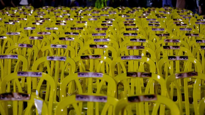 ISRAEL-PALESTINIANS/HOSTAGES Pictures of eyes are stuck onto empty chairs as people await news of hostages expected to be released by Hamas, amid a hostages-prisoners swap deal between Hamas and Israel, in Tel Aviv, Israel, November 25, 2023. REUTERS/Alexander Ermochenko