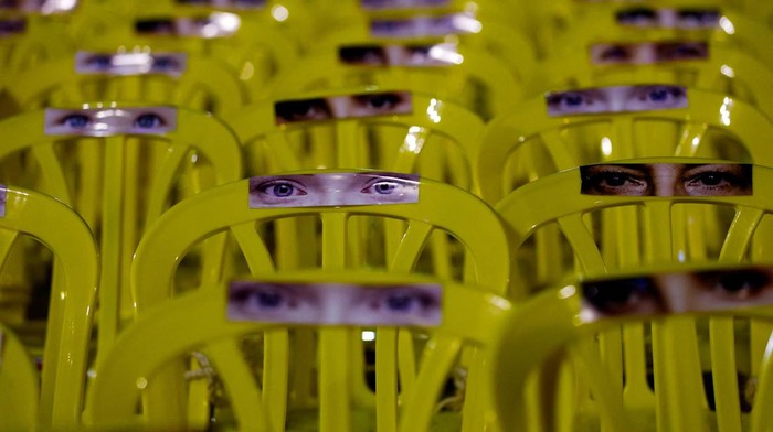 ISRAEL-PALESTINIANS/HOSTAGES Pictures of eyes are stuck onto empty chairs as people await news of hostages expected to be released by Hamas, amid a hostages-prisoners swap deal between Hamas and Israel, in Tel Aviv, Israel, November 25, 2023. REUTERS/Alexander Ermochenko