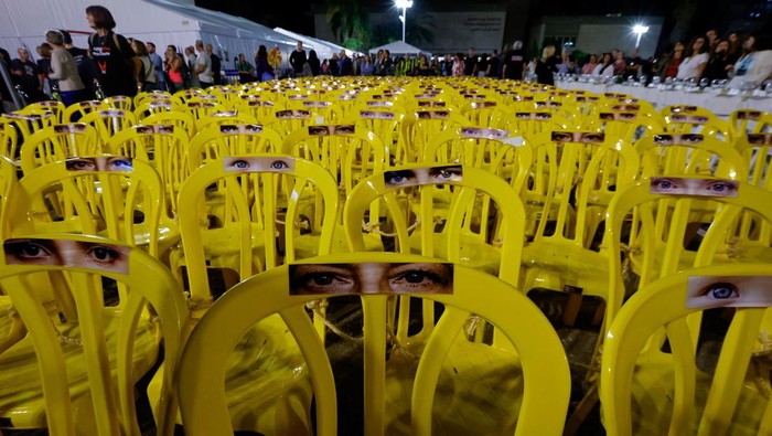 ISRAEL-PALESTINIANS/HOSTAGES Pictures of eyes are stuck onto empty chairs as people await news of hostages expected to be released by Hamas, amid a hostages-prisoners swap deal between Hamas and Israel, in Tel Aviv, Israel, November 25, 2023. REUTERS/Alexander Ermochenko