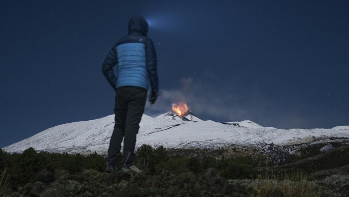 Lava erupts from snow-covered Mt Etna volcano, Sicily, Italy, early Saturday, Nov. 25, 2023. Europe's most active volcano remains active scattering ashes around a vastly populated area on its slopes. (AP Photo/Etnawalk, Giuseppe Di Stefano)