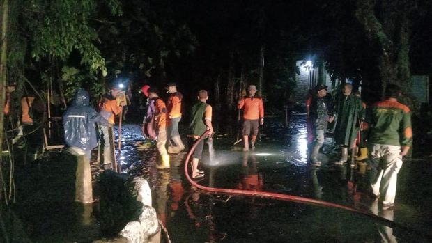 Upaya pembersihan lumpur sisa banjir bandang di Desa Wonosoco, Kecamataan Undaan, Kudus, Jumat (24/11/2023) malam.