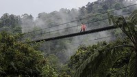 Pengunjung melintas di jembatan gantung Lembah Purba di kawasan wisata Situgunung, Kadudampit, Kabupaten Sukabumi, Jawa Barat, Minggu (26/11/2023).