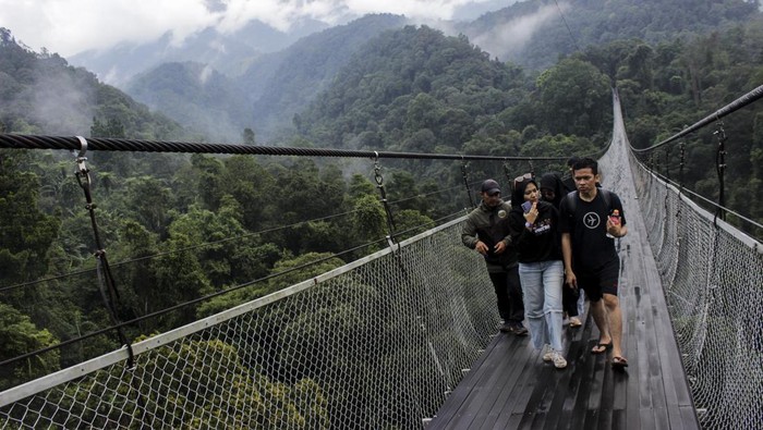 Berfoto Berekspresi di Jembatan Gantung Lembah Purba Pengunjung melintas di jembatan gantung Lembah Purba di kawasan wisata Situgunung, Kadudampit, Kabupaten Sukabumi, Jawa Barat, Minggu (26/11/2023). Kementerian Pariwisata dan Ekonomi Kreatif menargetkan kunjungan wisatawan mancanegara naik menjadi 12-14 juta pada 2024 dibandingkan target 2023 sebanyak 8,5 juta kunjungan dan target pergerakan wisatawan nusantara kisaran 1,2 miliar - 1,4 miliar pada 2024. ANTARA FOTO/Henry Purba/agr/nym.