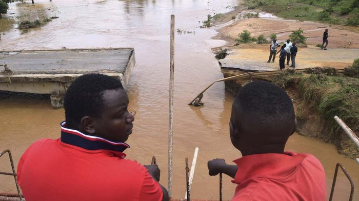 Travellers who were headed to either Malindi town or Mombasa town had to alight from their vehicles Saturday Nov. 25, 2023 and walk on foot across the unfinished Mbogolo bridge with their luggages to the other side after floods washed away a section of the old bridge due to heavy downpour on Friday night,